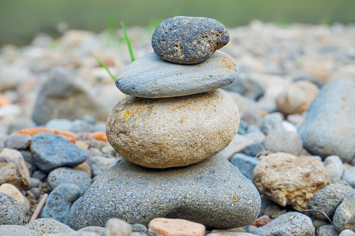 A rock pile object arranged on the bank of a river.