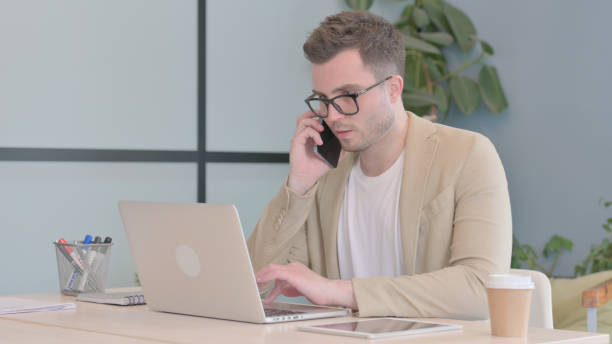 istock Young Businessman Talking on Phone at work 1594194670