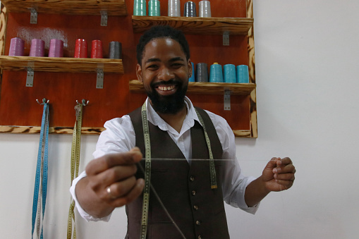 black man tailor happy positive small business needle