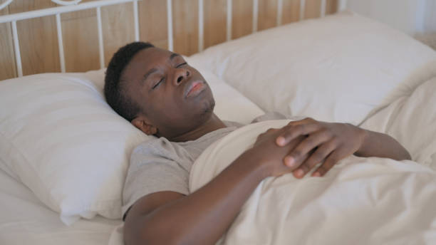 istock Young African Man Waking Up and Leaving Bed 1594203638