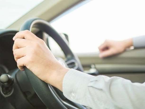istock Close up of a man driving car using one hand, dangerous behavior 1594205971