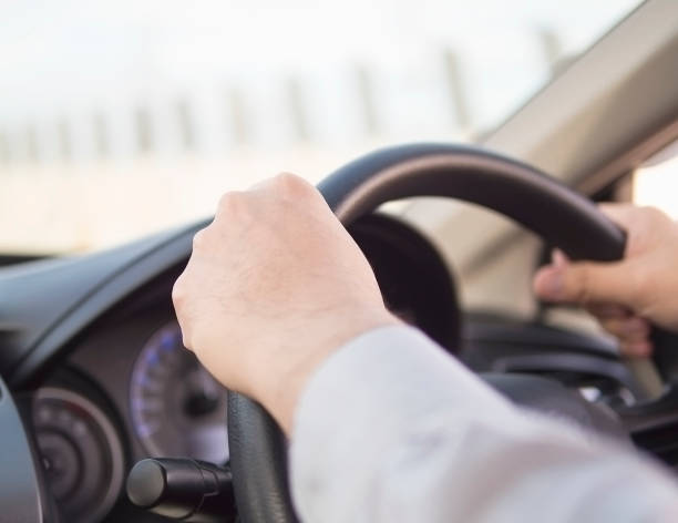 istock Close up of a man driving car using two hands 1594206369