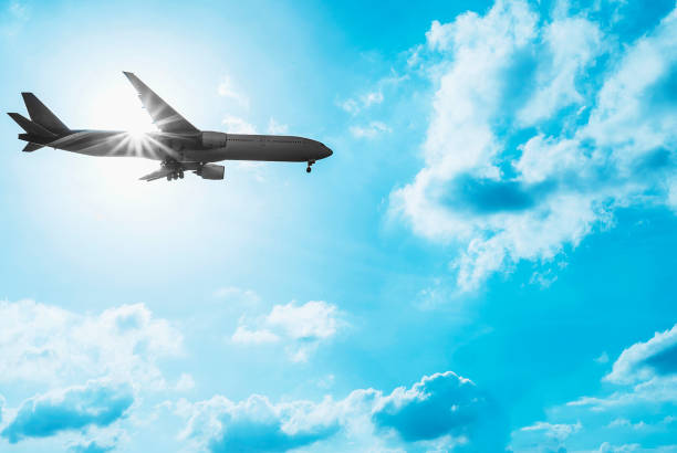 istock Silhouette airplane in the blue color tone sky with sun light from behind 1594207162