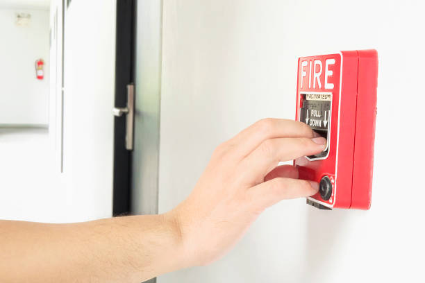 istock Man is reaching his hand to push fire alarm hand station 1594208484