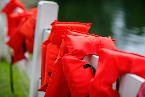 Life jackets on a white fence