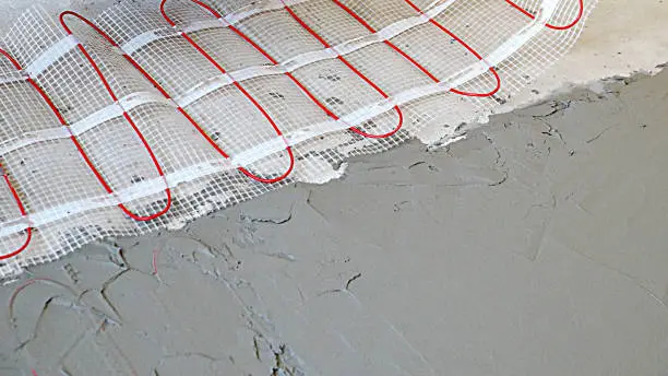 Photo of installation of an electric cable underfloor heating on the floor under a cement screed close-up