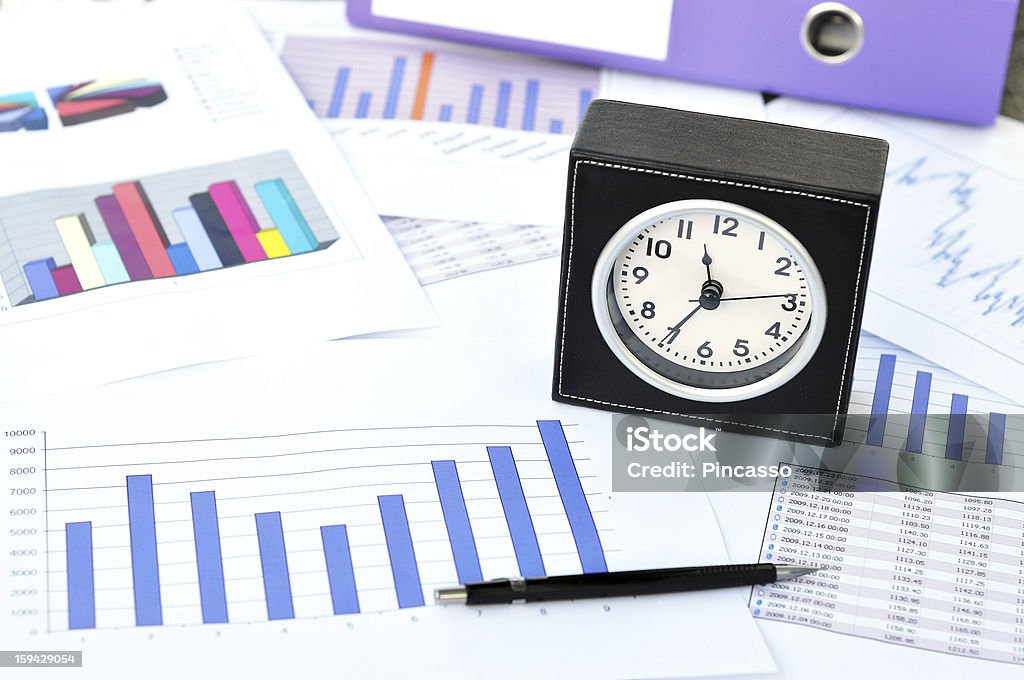 Clock, files and pen on a market report Balance Stock Photo