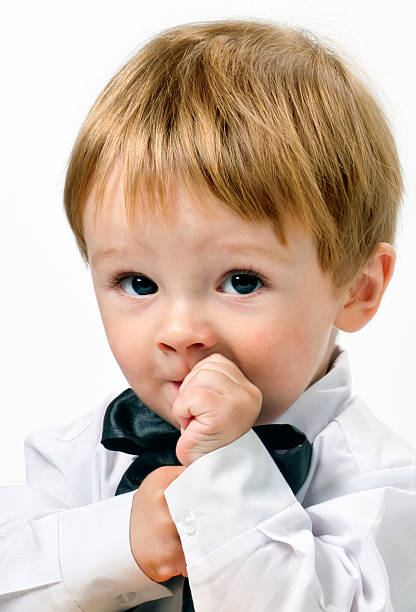 Pretty little boy in white shirt and black bow -tie. stock photo