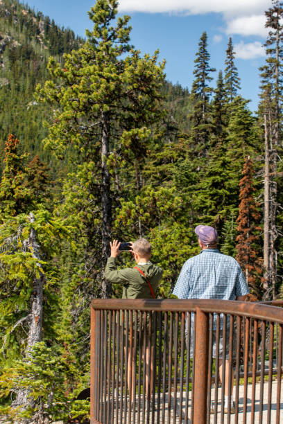 Travelers taking snapshot on smart phone of North Cascade Mountains Okanogan WA USA June 23, 2023 - Visitors taking photos at the HWY 20 observation overlook in the North Cascade Mountains liberty bell mountain stock pictures, royalty-free photos & images