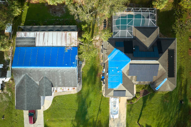 istock Hurricane Ian damaged house rooftops covered with protective plastic tarp against rain water leaking until replacement of asphalt shingles. Aftermath of natural disaster 1594392890