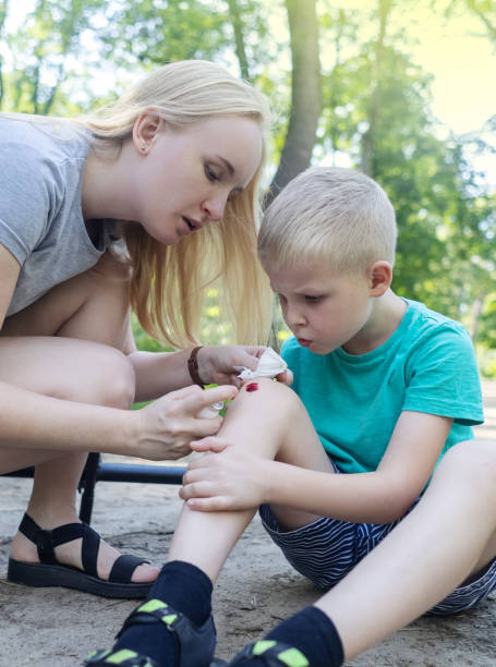istock Kid fall when riding an electric scooter. Riding an e-scooter without protective gear. Increased risk of injury when using battery powered vehicles. Mom gives first aid for a knee injury 1594443280