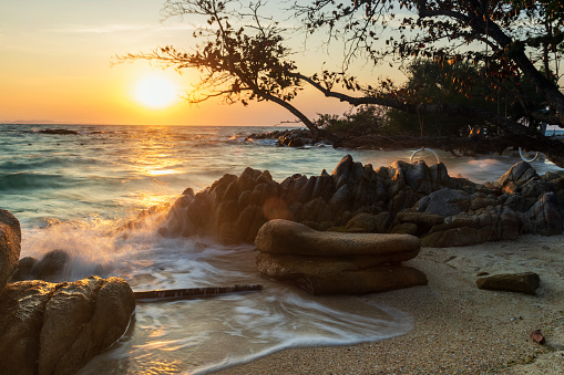 Beautiful seascape of motion wave through stone arch at sunrise in Ko Man Klang, Rayong, Thailand. Famous travel destination and summer holiday vacation in tropical country, Siam.