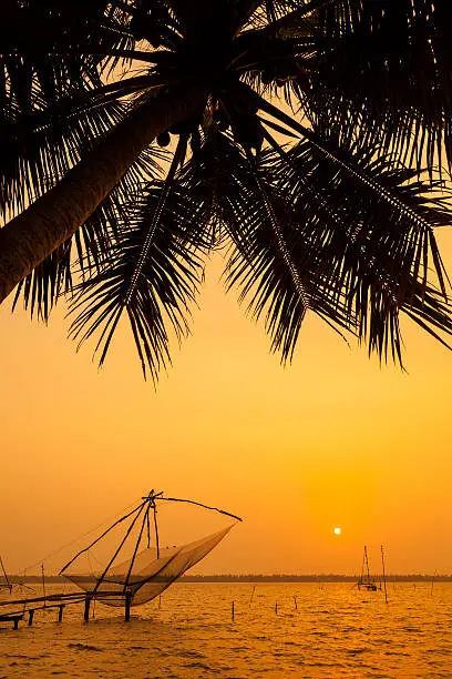 chinese net and fishing boat at sunset in Cochin (Kochi), Kerala, India