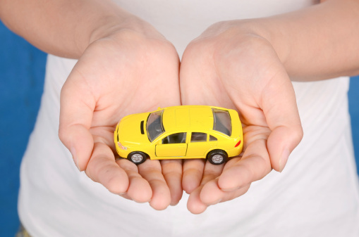 a yellow toy car in woman hand