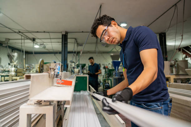 Latin American employee working at a manufacturing factory and doing quality control on some battens