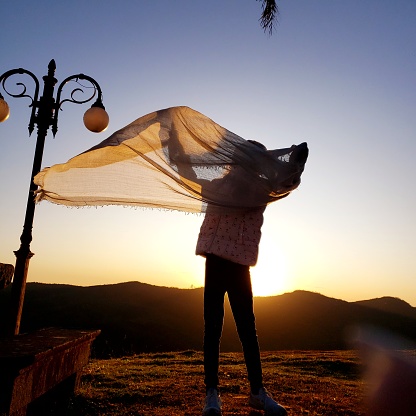 Child with fabric at sunset