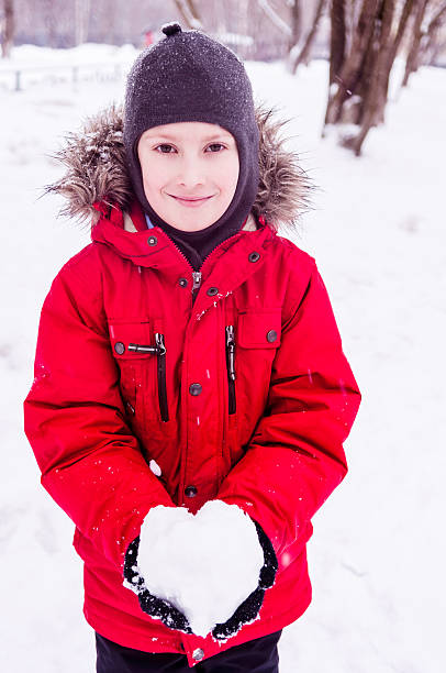 istock Smiling boy holding snow heart 159456910