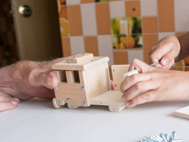 istock A five-year-old boy independently assembles a wooden construction kit with a screwdriver. Hands close-up. 1594574457