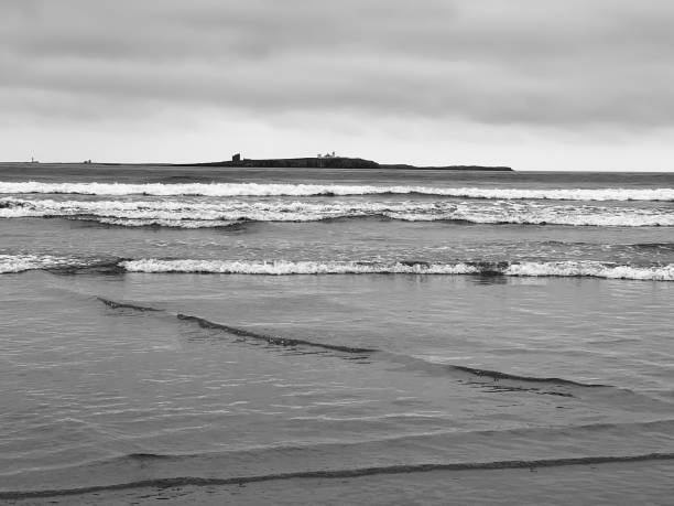 eine insel vor der küste von bamburgh - bamburgh northumberland england white beach stock-fotos und bilder