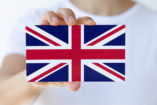 Hand is showing British flag to camera.