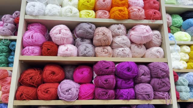 Close-up of woolen threads of different colors in a store on a shelf