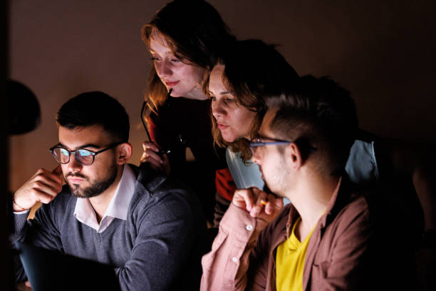 istock Group of business people solving a problem with a project late at night 1594626886