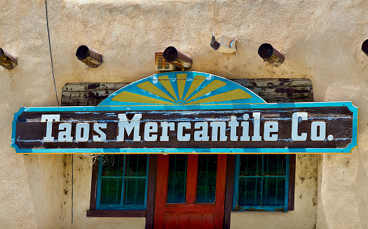 Taos, New Mexico, USA - July 24, 2023: Close-up view of the “Taos Mercantile Co.” store sign located on the Taos Plaza, a popular tourist destination in northern New Mexico.