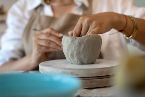process of shaping ceramic clay into a mug at handmade ceramic workshop, woman shaping ceramics in the ceramics workshop