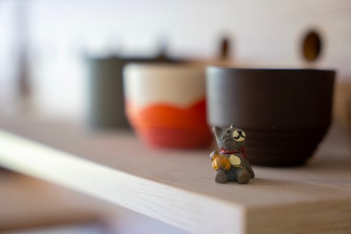 tiny teddy bear and handmade ceramic cups on the shelf