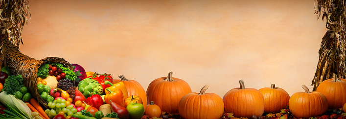 Thanksgiving day concept. Top view photo of vegetables pumpkins zucchini corn pattypans apples pears peppers gourds sunflowers nuts rowan on isolated orange background with empty space in the middle
