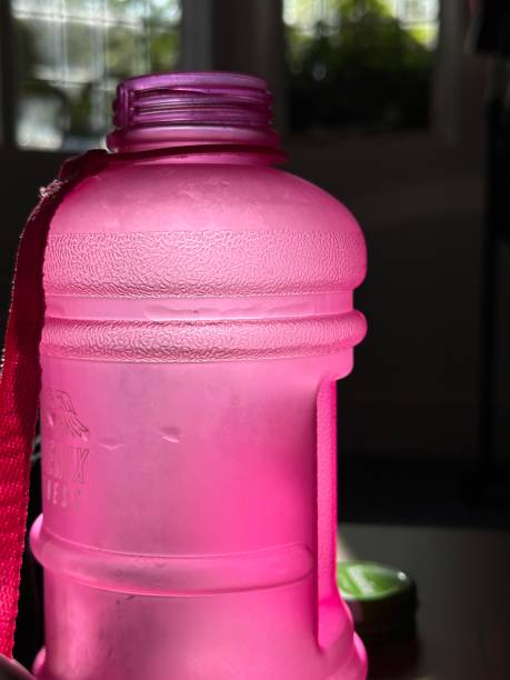 Cropped closeup of a pink sports bottle glowing in the sunlight