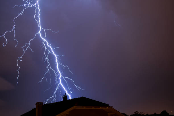 мощный удар молнии над крышей дома - global warming flash стоковые фото и изображения