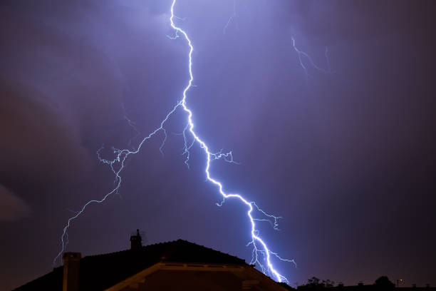 istock Powerful lightning strike above house roof 1594724483