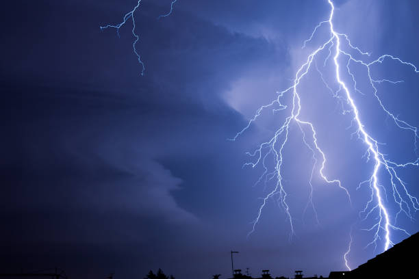 istock Powerful lightning strike above city roofs 1594724491