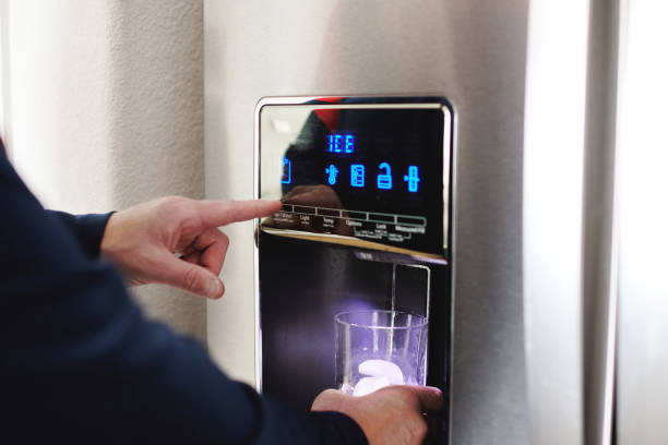 Unidentifiable male using an ice machine on a modern refrigerator Unidentifiable male using an ice machine on a modern refrigerator Ice Maker stock pictures, royalty-free photos & images