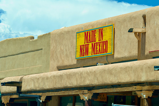 Taos, New Mexico, USA - July 24, 2023: A painted, wooden sign atop the “Made in New Mexico” storefront on Taos Plaza advertises the purpose of the retail establishment inside.