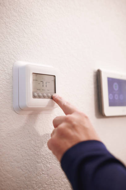 istock Unidentifiable male using a thermostat in a modern home 1594842791