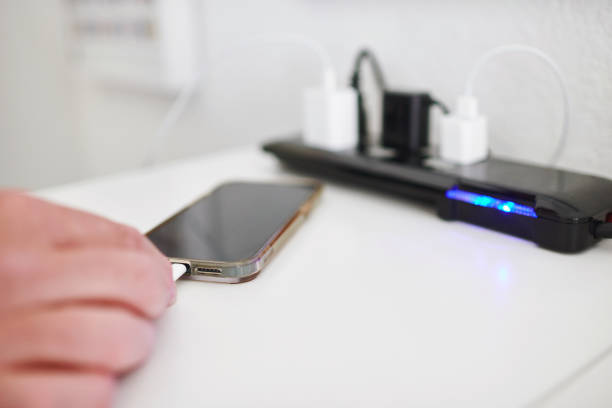 istock Unidentifiable male plugging a charging cable into a smart phone 1594847941