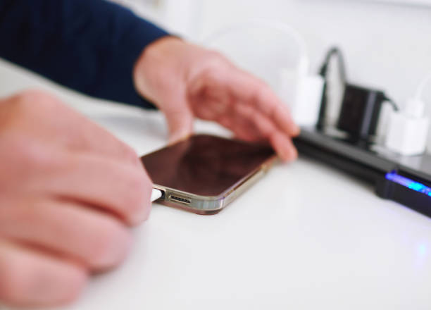 istock Unidentifiable male plugging a charging cable into a smart phone 1594847948