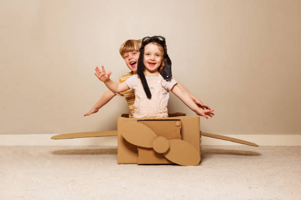 istock Boy play cardboard plane, wears hat, glasses pretends to fly 1594924052