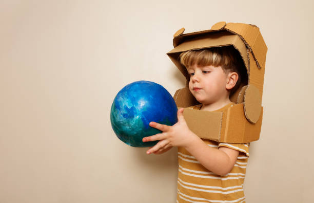 istock A child with cardboard astronaut helmet holds earth planet 1594924071