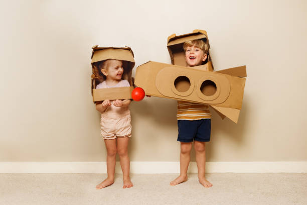 istock Kids with cardboard rocket and helmets hold red planet model 1594924605