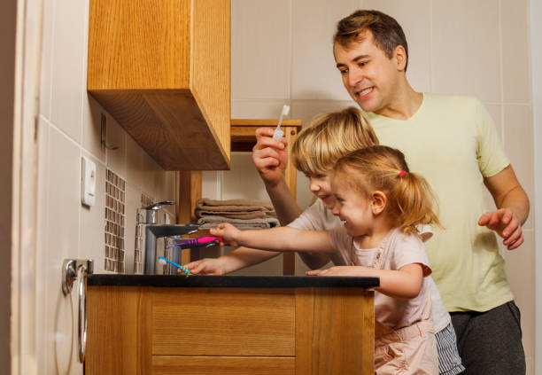 istock Dad with two kids brush teeth using toothbrush at bathrooms 1594936647