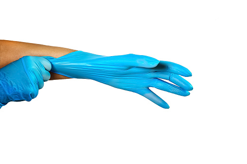 Doctor nurse cleaning Female hands tinghten blue medical latex gloves on a white background. Isolated, copy space