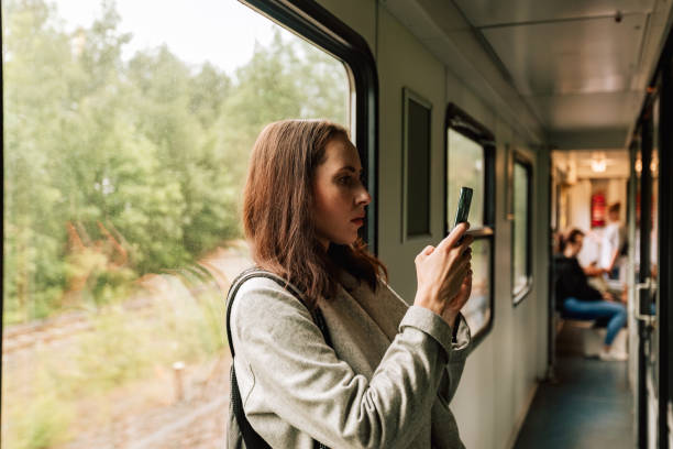 istock Female portrait of passenger who using mobile phone in train 1595036066