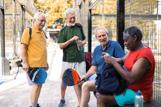 istock Four cheerful seniors preparing for a Paddle Tennis game in doubles 1595071083