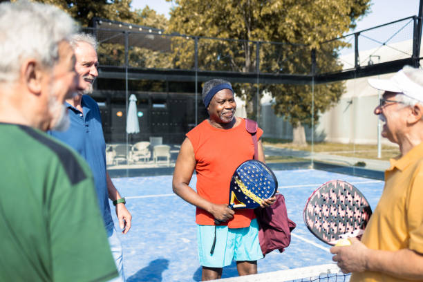 istock Four cheerful seniors enjoying at talking while playing Paddle Tennis 1595072152