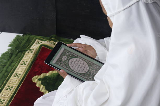 istock Muslim girl reading electronic Quran on tablet 1595391639