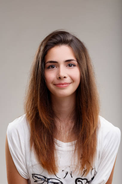 Long-haired girl smiles; adolescence symbolizes growth