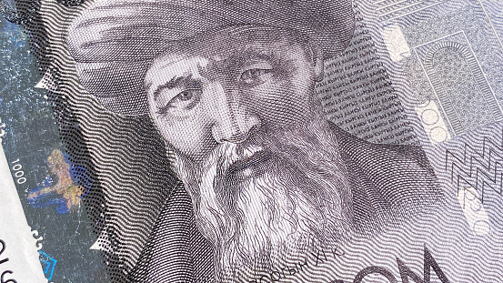 Close-up of the portrait of the writer Yusuf Balasaguni on a bill of 1000 som. Cash banknotes of Kyrgyzstan. One thousand som. Background of the Kyrgyz national currency. The current money of Kyrgyzstan. Economics and finance.
